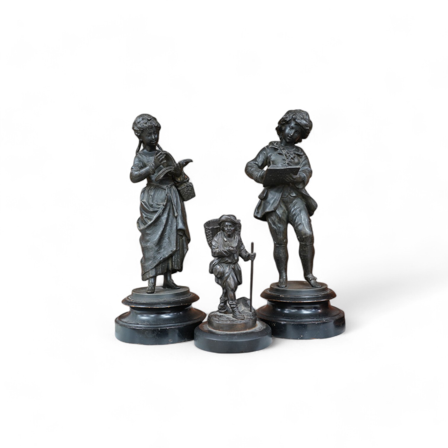 A Victorian bronze figure of a man carrying basket and a pair spelter figures, 32cm. Condition - fair to good, a little worn, particularly bases